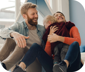 Family smiling together while a mother holds her child