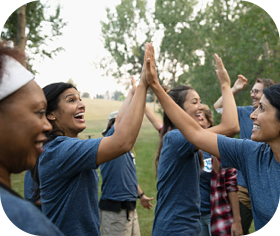 Group of people volunteering and giving high fives to each other